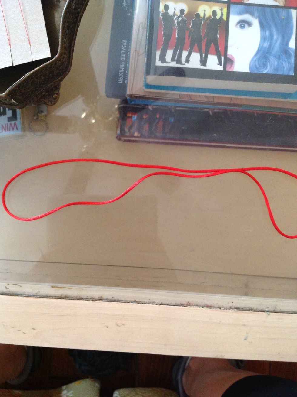 Next, we will try a Basket Weave. You will grab a new piece of string and fold it so you are holding two strings to begin weaving.