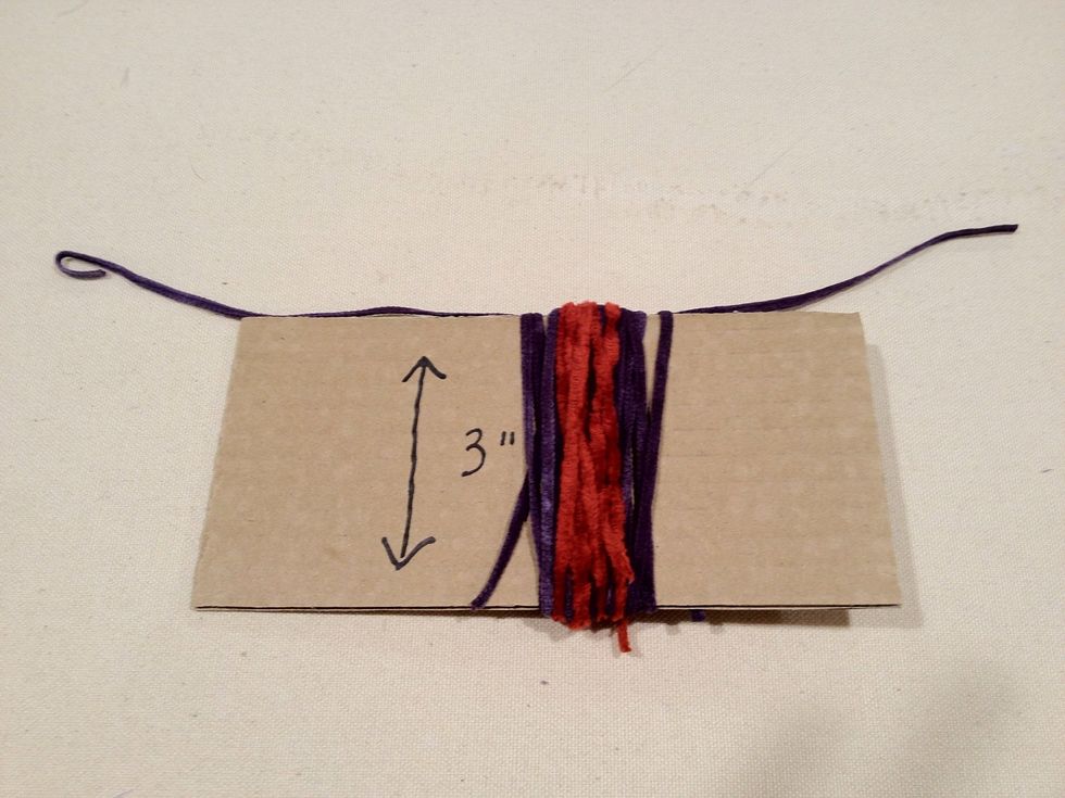 Next wrap the accent color yarn around the cardboard about 6 times. You can experiment with different colors to achieve the look you want.