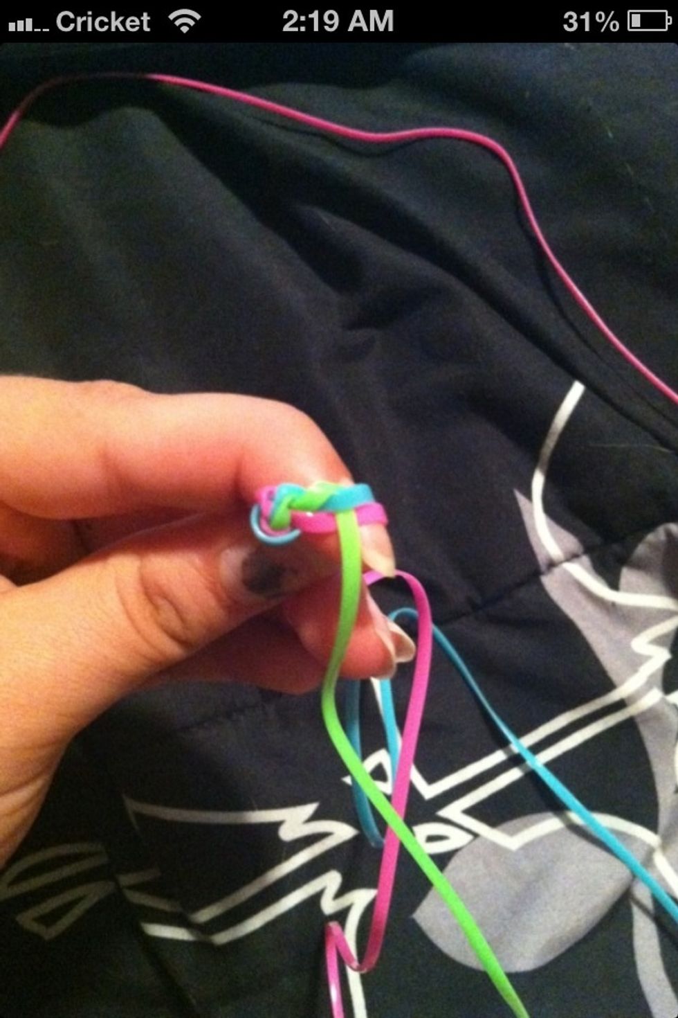 Next wrap the green lace under the blue and over the pink lace.