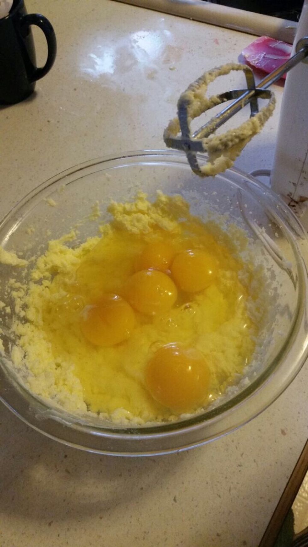 Next you add the 5 large eggs in the same bowl as the sugar and butter