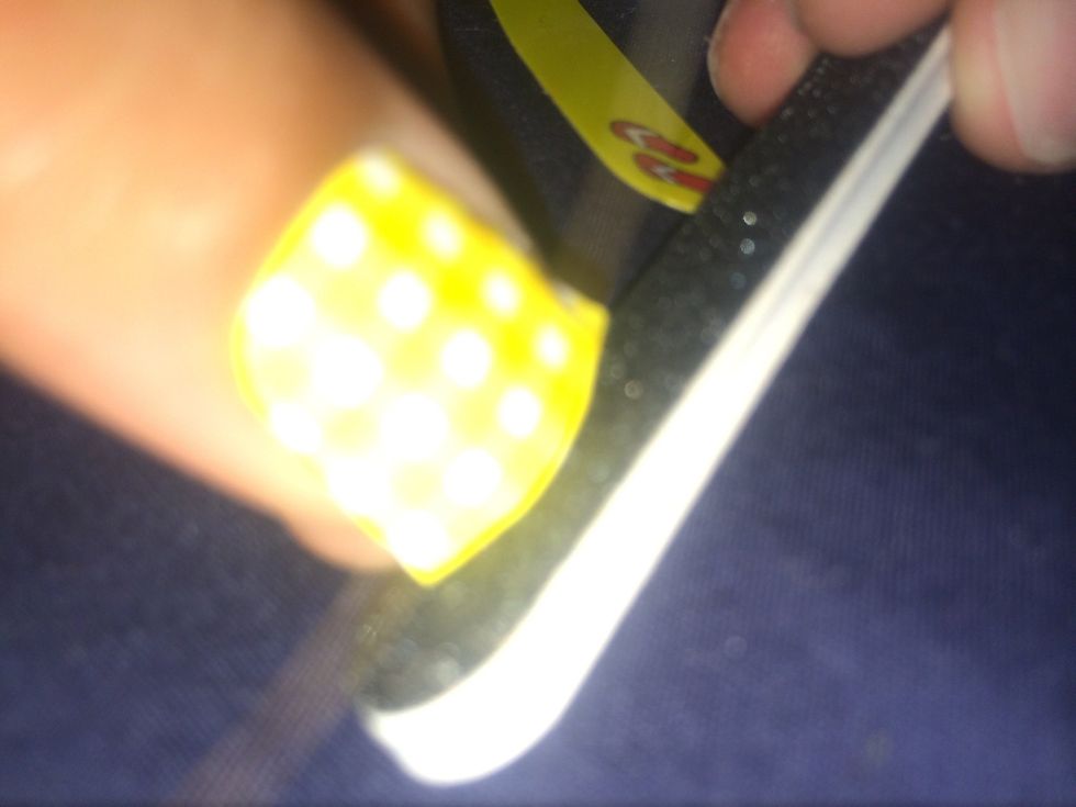 Next you'll file off the excess sticker. I find that it's easier if you start at the tips of your nails and you only file in one direction. You'll get less rips and wrinkles