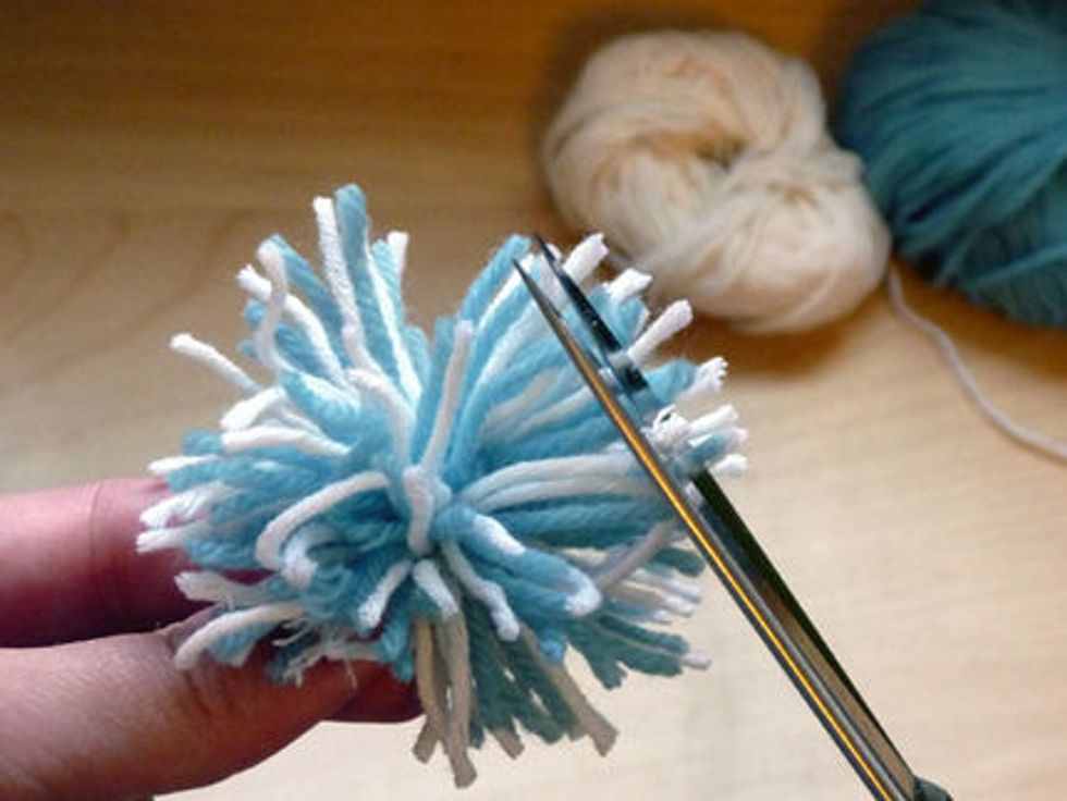 Next you must trim the long ends of the pompom.