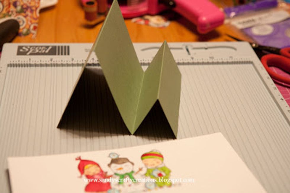 Next, you need to create a card base by cutting a piece of cardstock 5.5 inches wide x 12 inches long. Then use a score board and score at 2 inch, 4 inch and 8 inch. Fold the base like this.