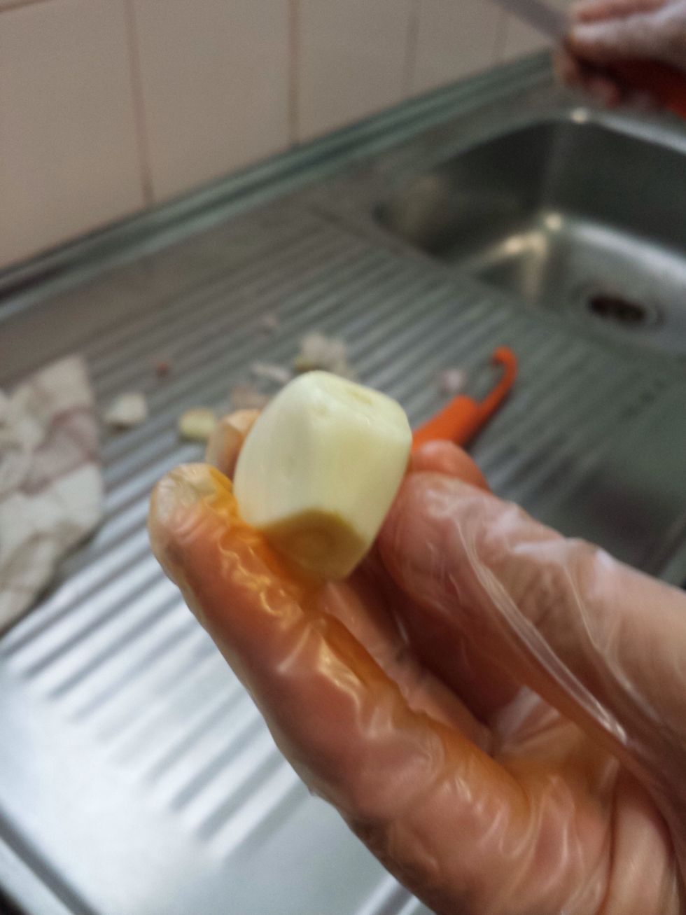 Next you need to peel the garlic. Cut both ends off it and peel off the skin.