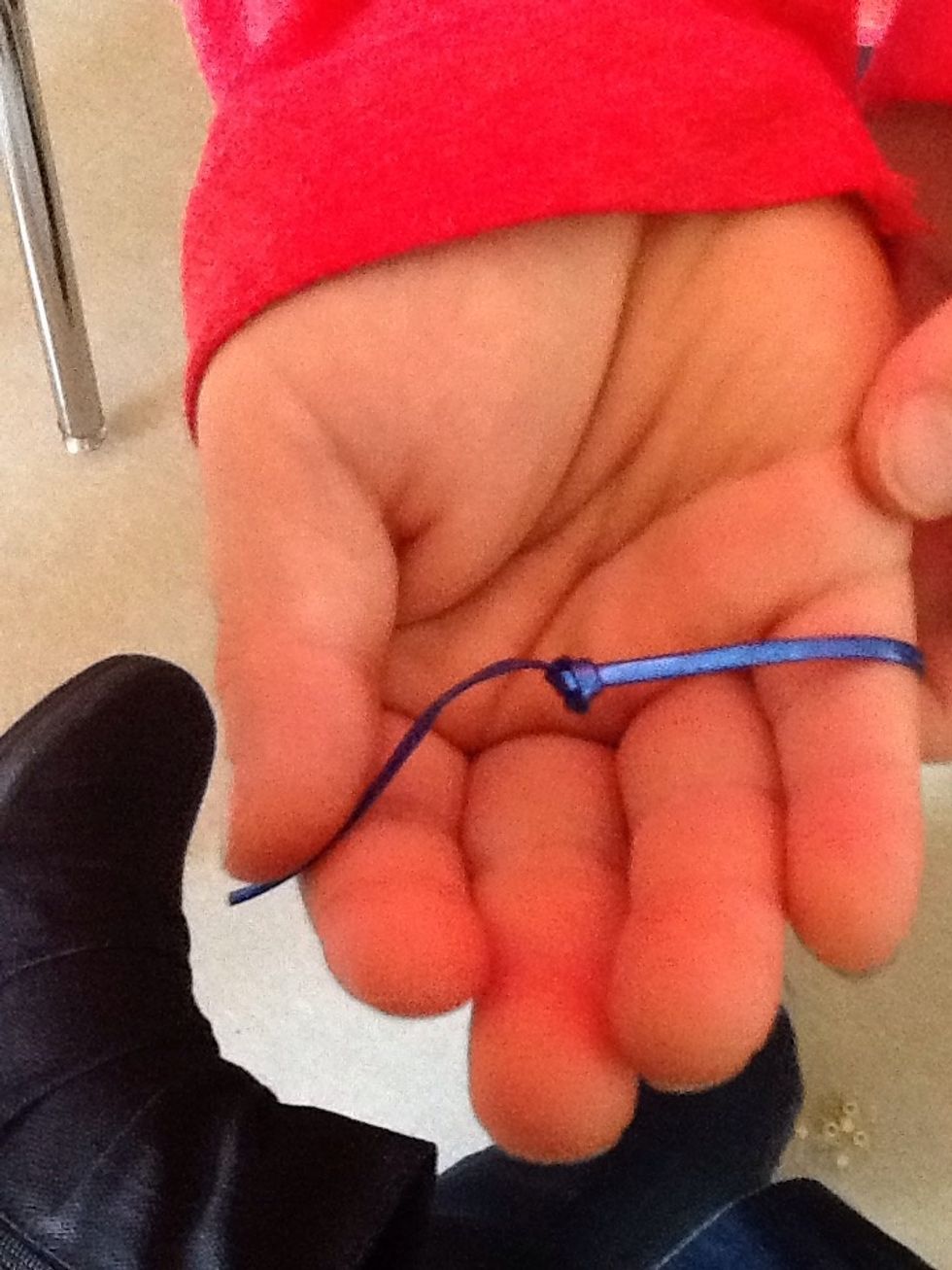 Next you need to tie a knot close to the end of the string. Try to leave 1-2 cm behind the knot to tie later.