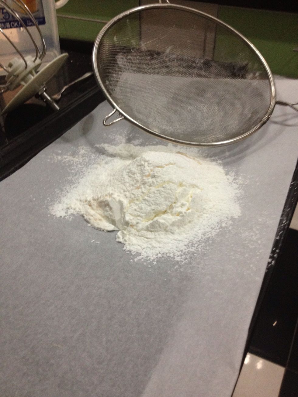 Next you want to sift the corn flour, custard powder, cream of tartar and baking soda. You could do this in a separate bowl but doing it on the parchment paper is just easier.