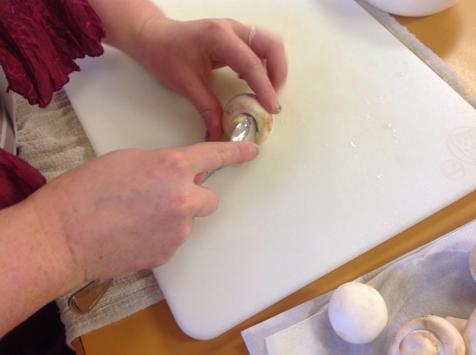 Next, you will remove the stem from the mushroom,leaving a deep carved out center. Take a spoon and use the spoon to go around the stem.