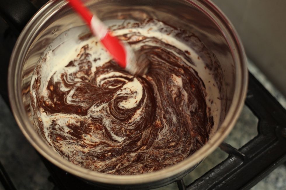 No need to be gentle. Go all out with your whisk or spoon until you have a smooth lump free chocolate. Let it cool down and put it in the fridge for a few hours or so. Doesn't have to be solid firm.