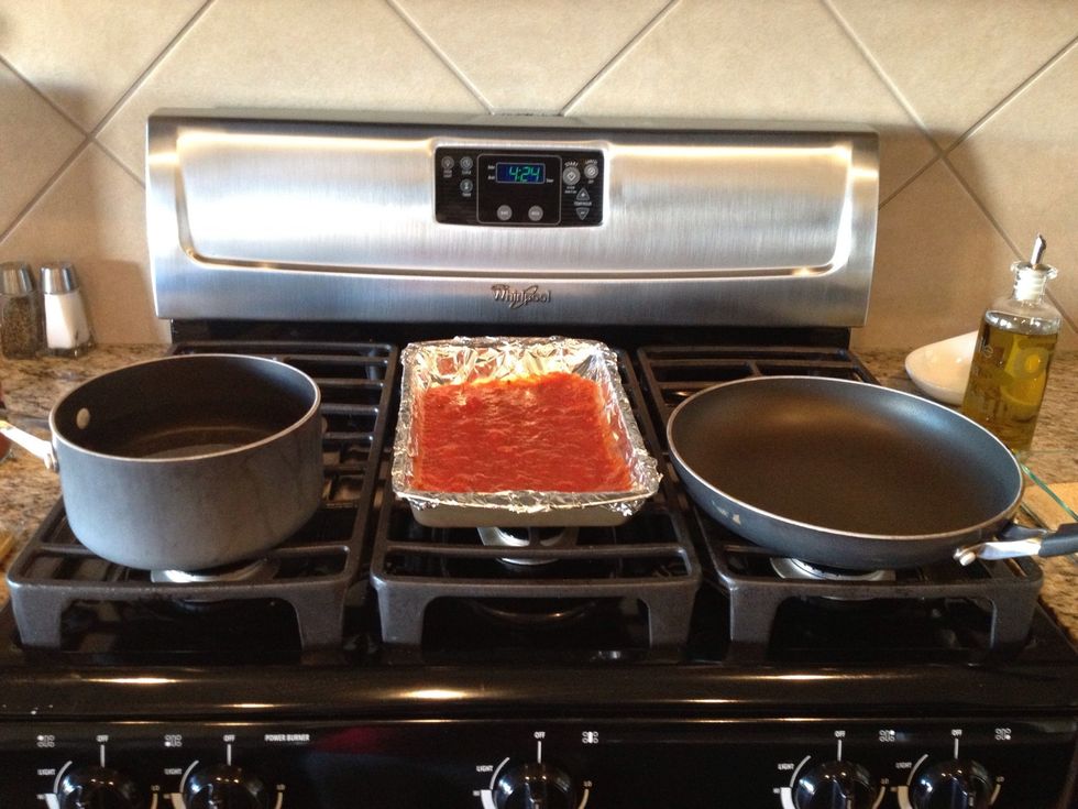 Noodles, baking pan with some spaghetti sauce, frying pan