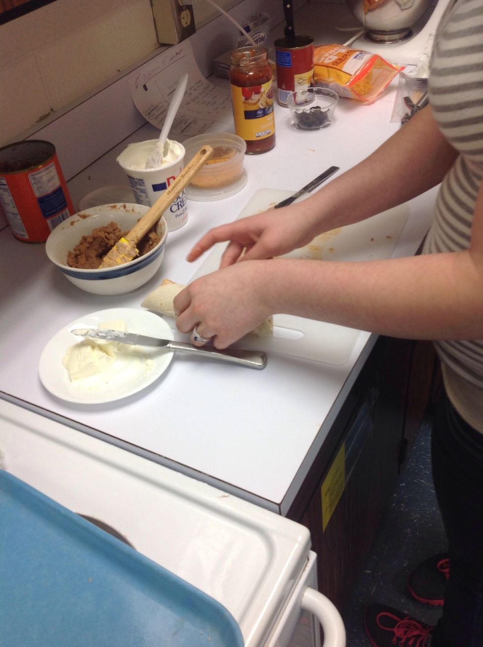 Nous r\u00e9partirons uniform\u00e9ment les olives, saupoudrer l'assaisonnement de la tortilla, et enroulez-le.