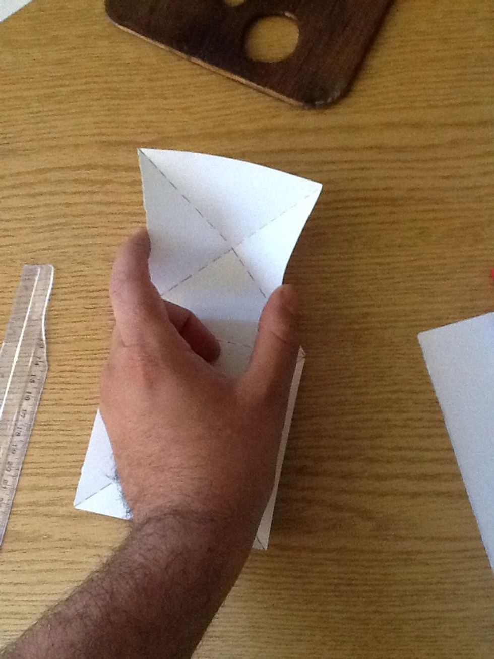 Now a tricky part.. Grab the middle of the base of two opposing triangle on the side of one square..