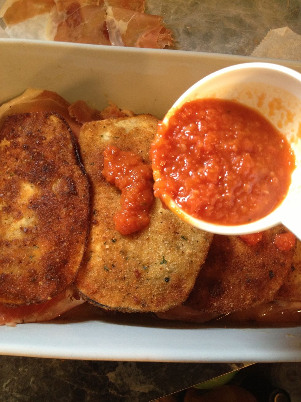 Now add a little of marinara sauce to each piece of eggplant.