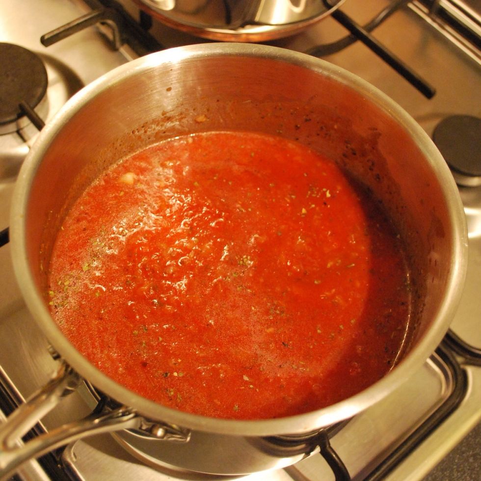 Now add in the passata. Fill the empty bottle up half way with water and swirl around and then add this to the pan too. Stir, season and simmer partly covered for 20 minutes