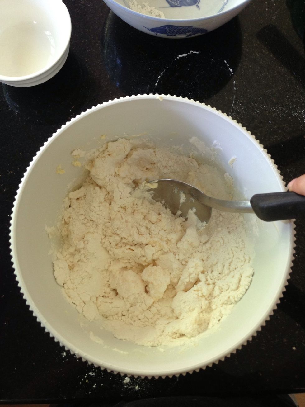 Now add in your dry mixture (sugar and flour) gradually, mixing as you go along. You should get a slightly moist pastry dough that looks like...