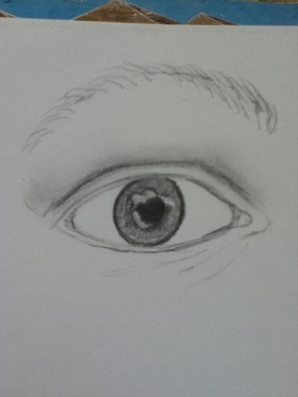 Now, add stress lines under the eye (we all have them,) the muscle around the tear duct, and define the eyebrow. For the eyebrow, be patient and make individual strokes with the pencil.