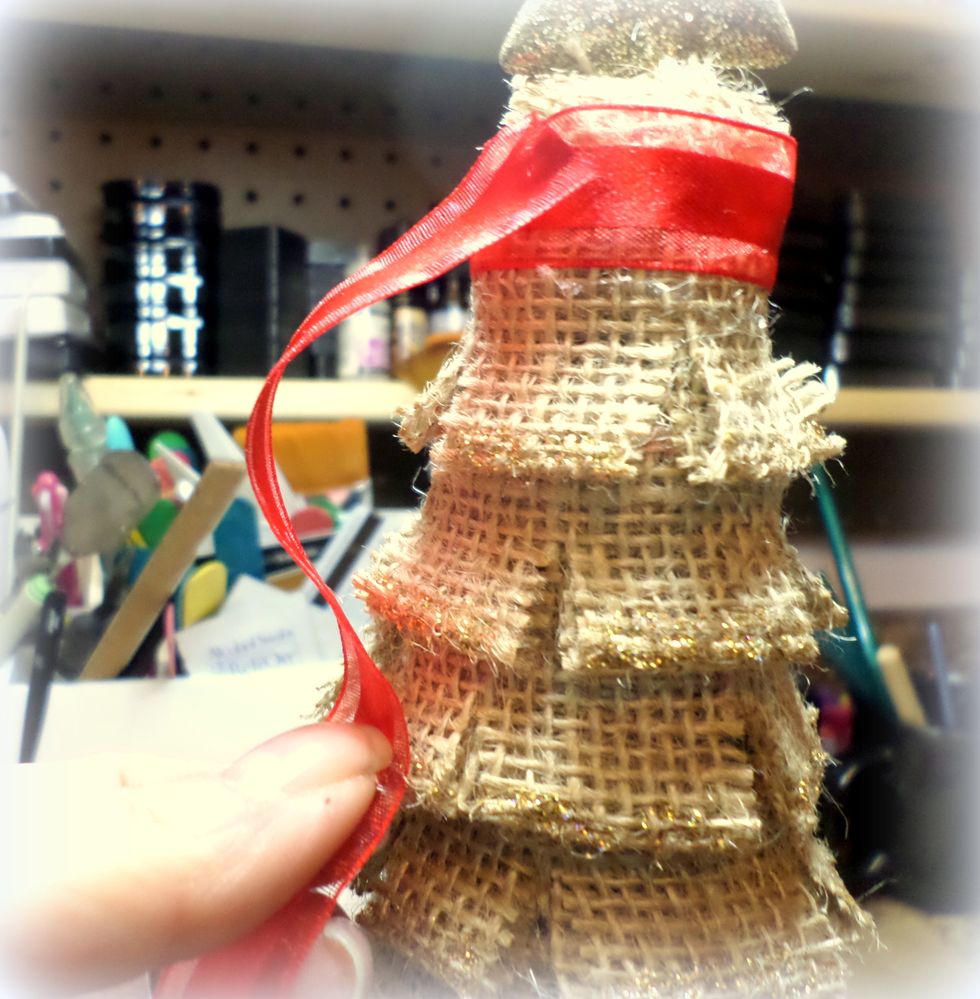 Now, add the ribbon! I used a piece around the top to give it a finished look. Take the ribbon you applied glue to and cascade it down the tree. I also made a bow for the top of the tree.