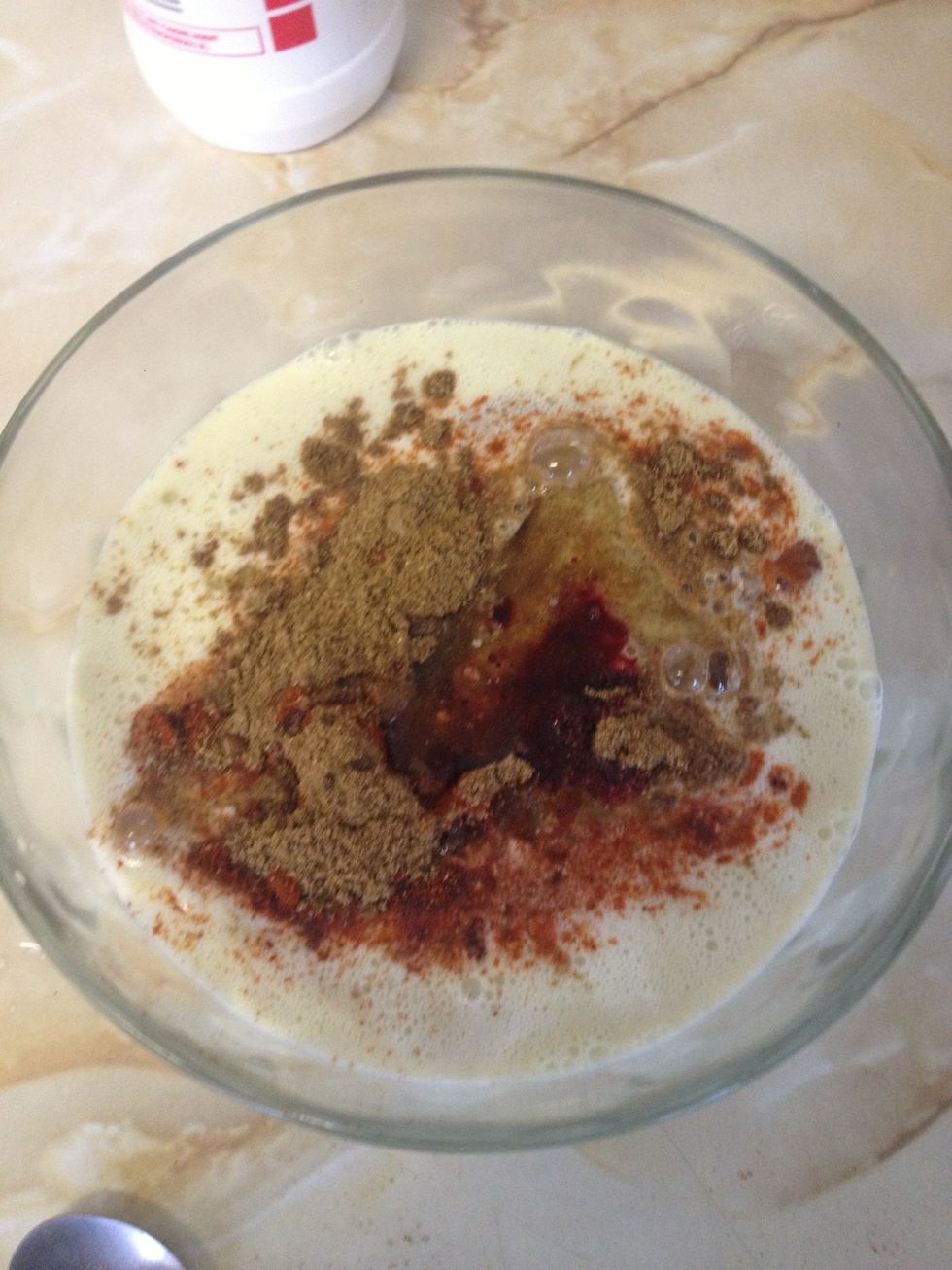 Now add the salt, chilli powder, cumin, garam masala, vinegar, cooking oil and red food colouring and beat it with a fork till it goes glossy and looks like ........