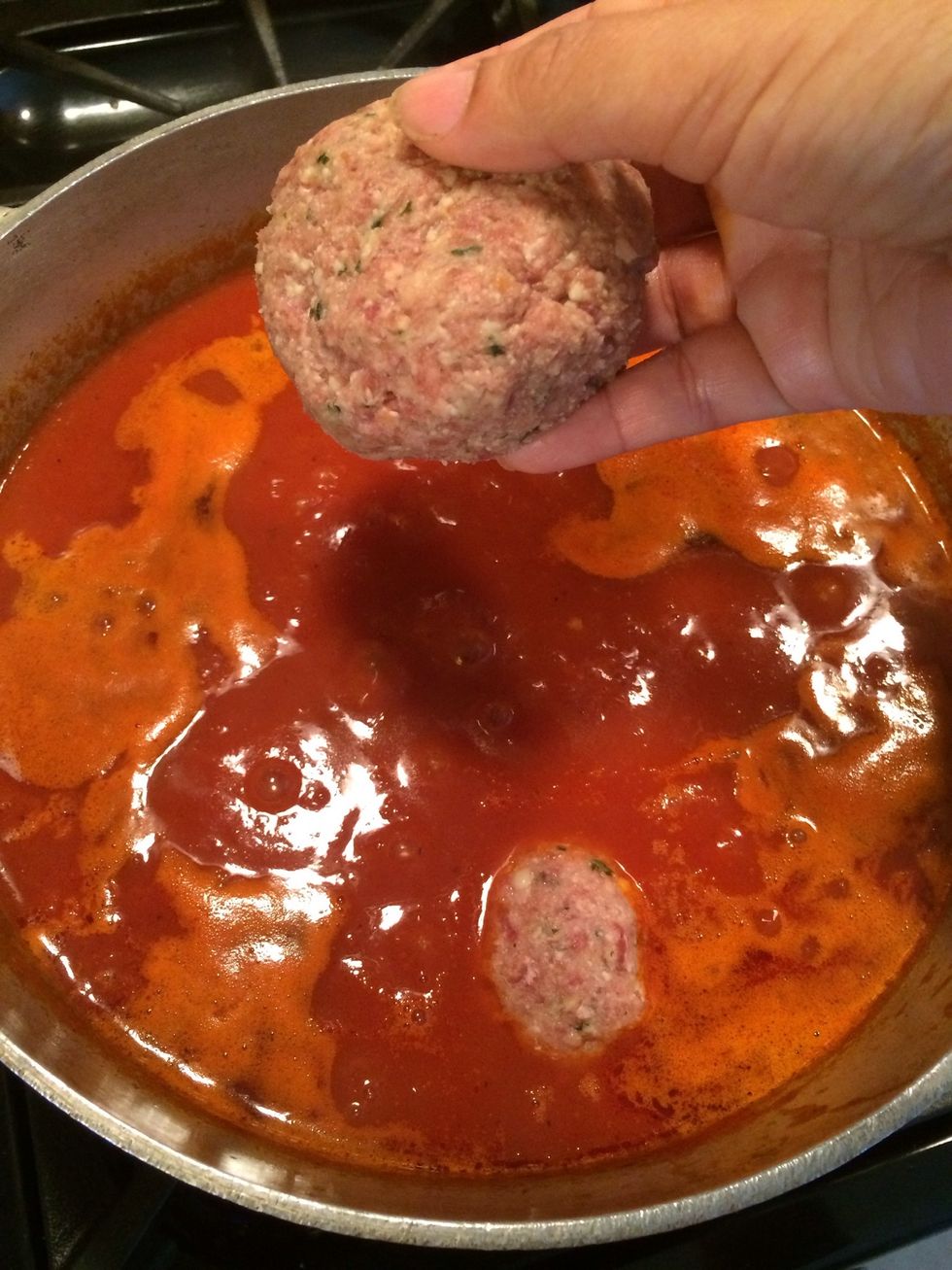 Now add your favorite meatballs to the pot of marinara sauce. Make your meatball slightly large. Like the size of a baseball, maybe a little smaller. We will be slicing them