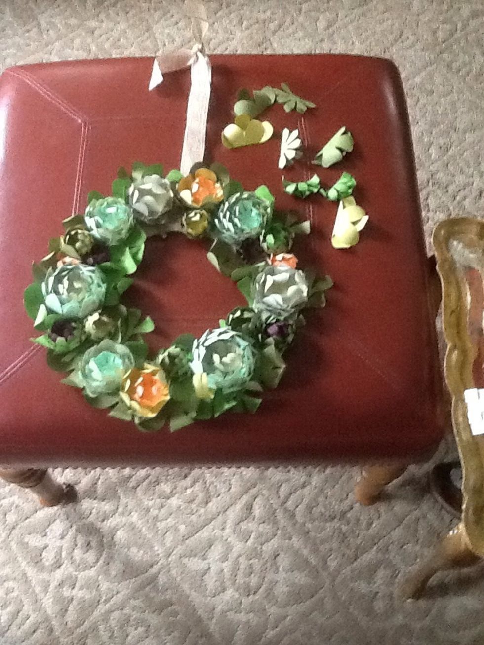 Now arrange your succulents on the wreath. You will have some extra fig and coral shapes hyper curl them, then put them in the wreath as well. Adhere them to the wreath with the foam squares .