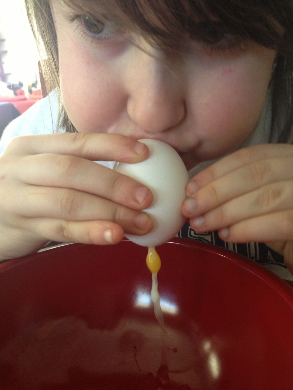 Now blow through the smaller hole. The egg will slowly come out the larger hole. Be careful not to squeeze the egg as you blow or it will break.