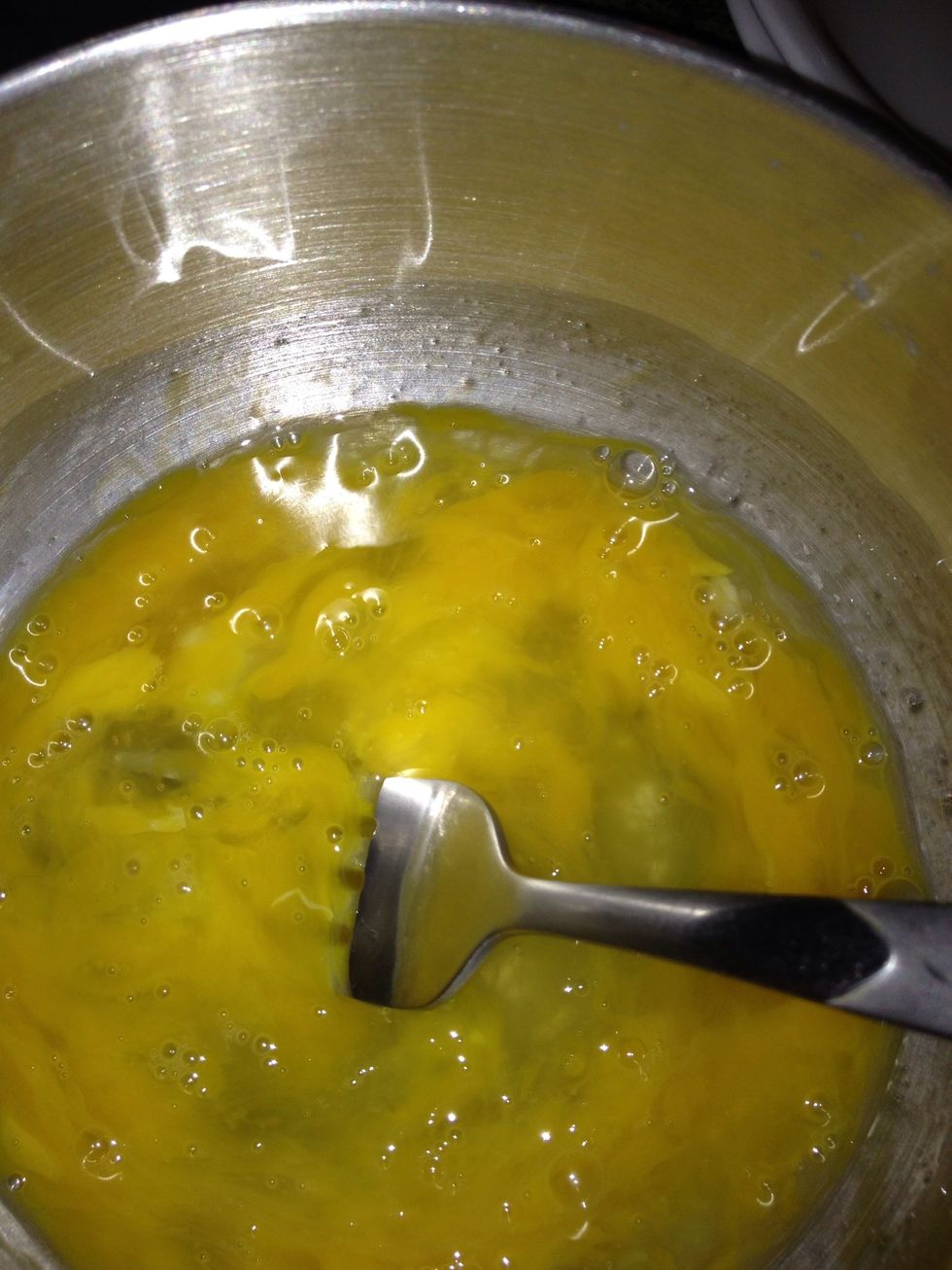 Now break your eggs I broke two because I made like four Mix away - turn the heat on your pan fill up with oil enough to fry the ball