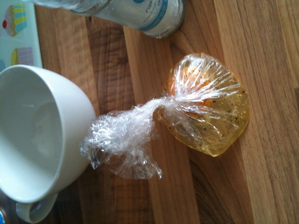 Now carefully and gently pull all the sides of the film together, while the egg is still in the cup. Then press and twist the wrap about two inches above the egg, ensuring that it's sealed, lift out.