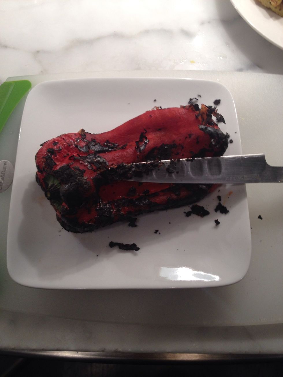 Now clean the charred skin from the pepper with a sharp knife or under running water.