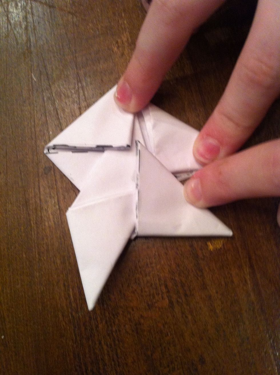 Now, clockwise, fold the triangle under the next one clockwise.