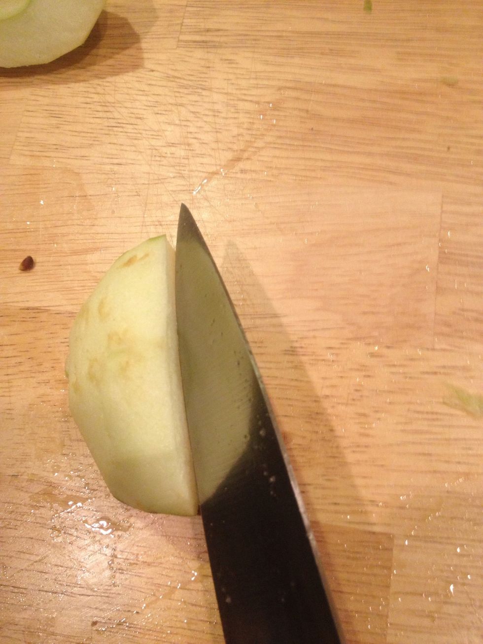 Now core the apples. Place apple quarter onto its side. Bringing knife down at a 45\u2022 angle in order to complete the coring in a single slice.