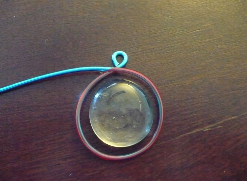 Now create a large loop/ring below the small loop of wire. Use the gem as a guide. You want this loop to be slightly larger than the gem so as to create a frame.