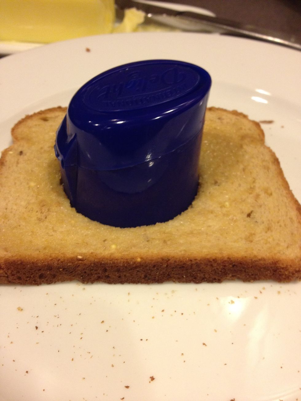 Now cut a hole with the lid right through the middle of the bread.