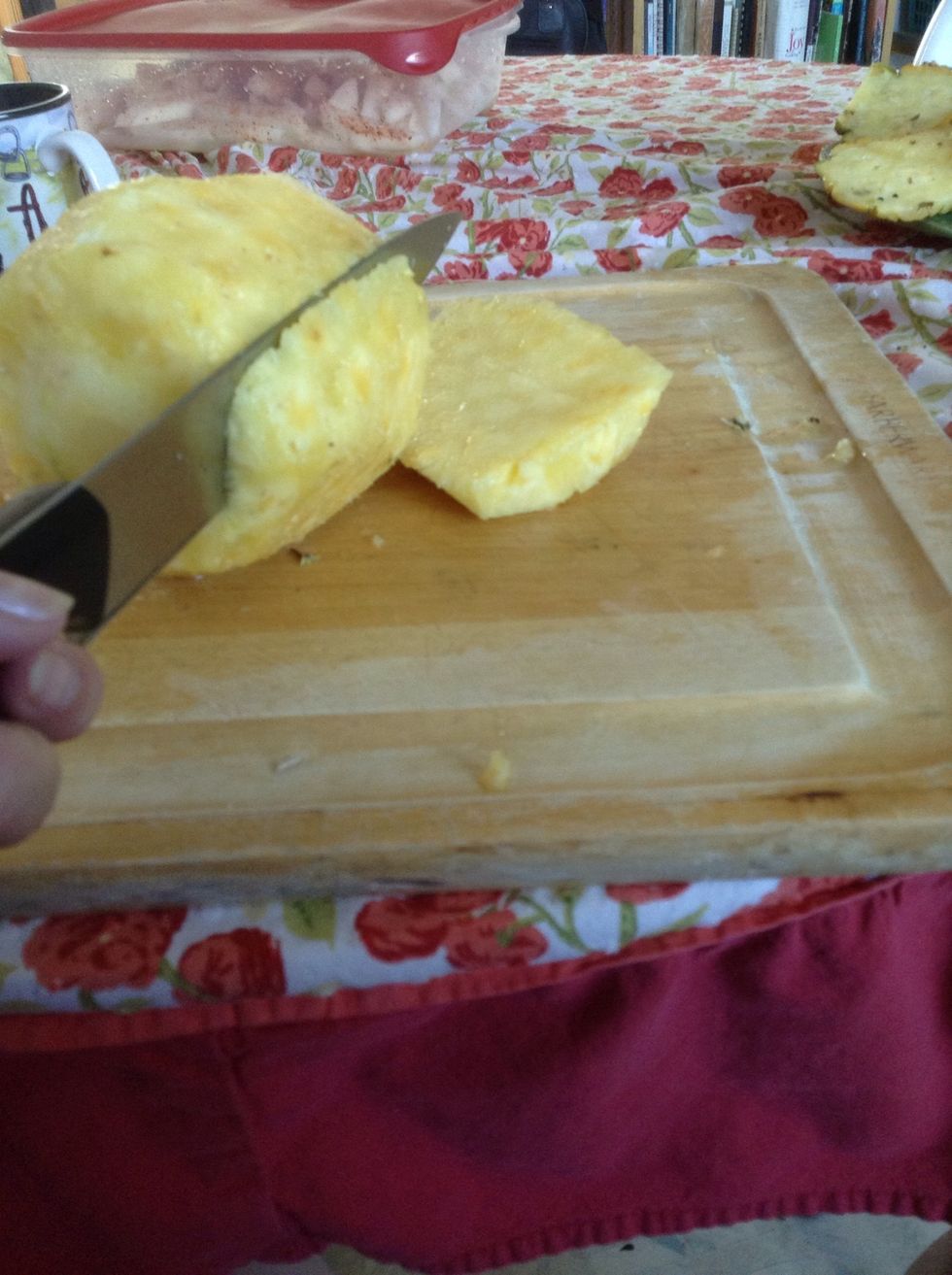 Now cut around the outer part of the pineapple into large slices like this.