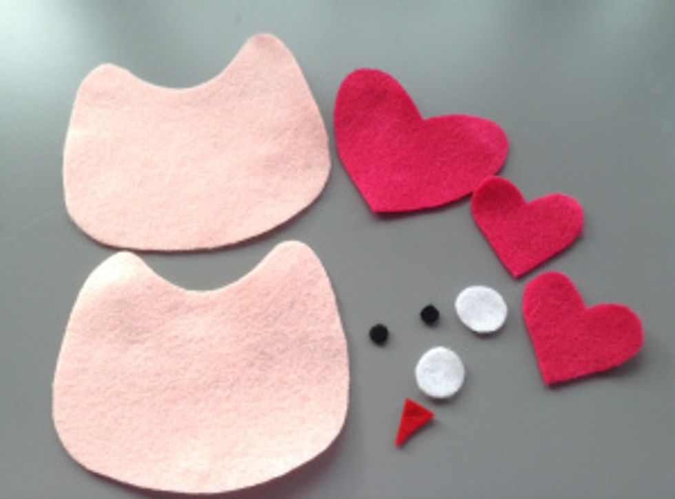 Now cut out a large heart for the face and two smaller hearts for the wings. Cut out two white circles and two smaller black circles for the eyes, and finally a triangle for the beak.