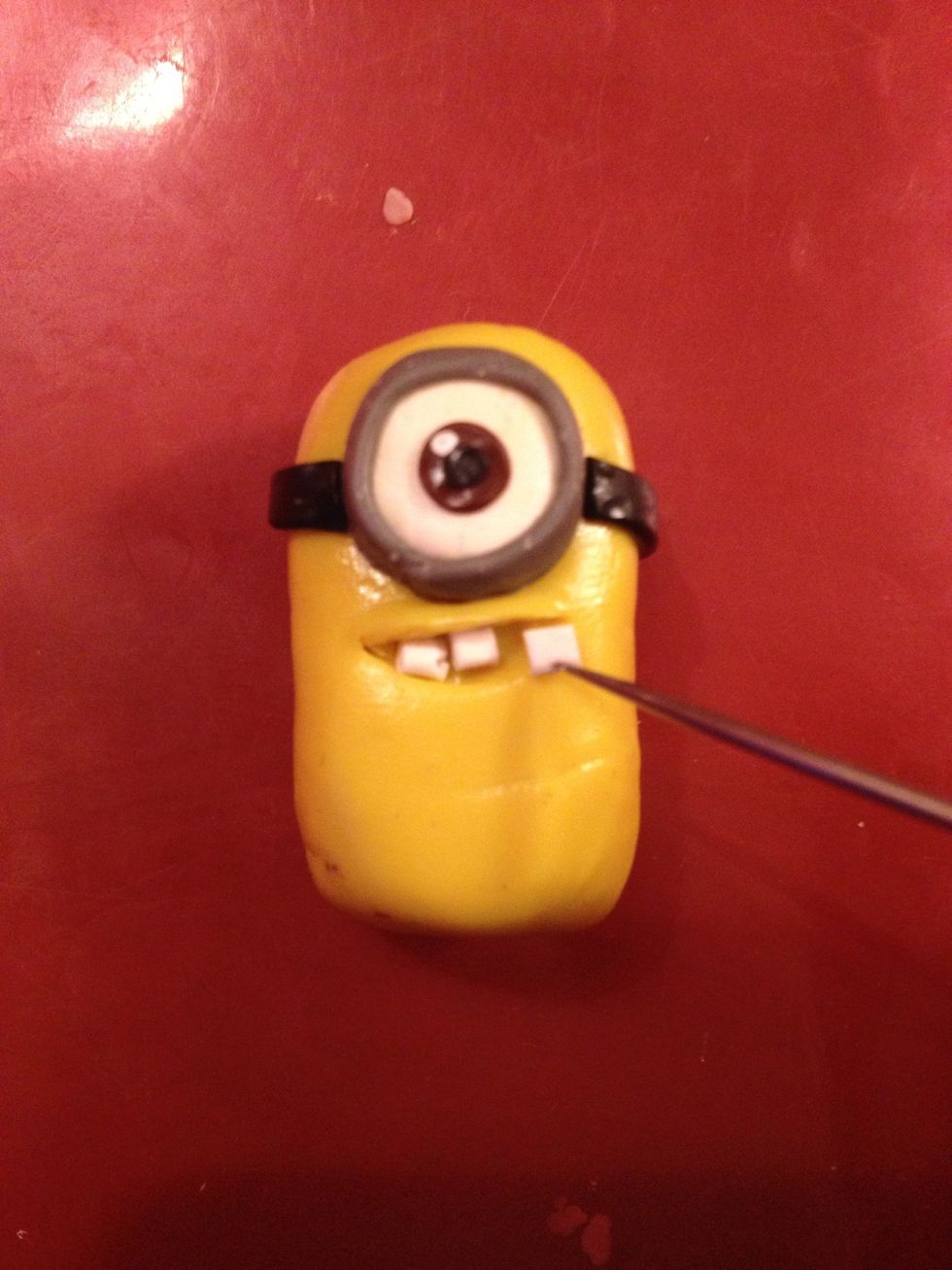 Now cut out some teeth - white squares - and put it to the mouth. Do you feel yourself like minion's dentist?