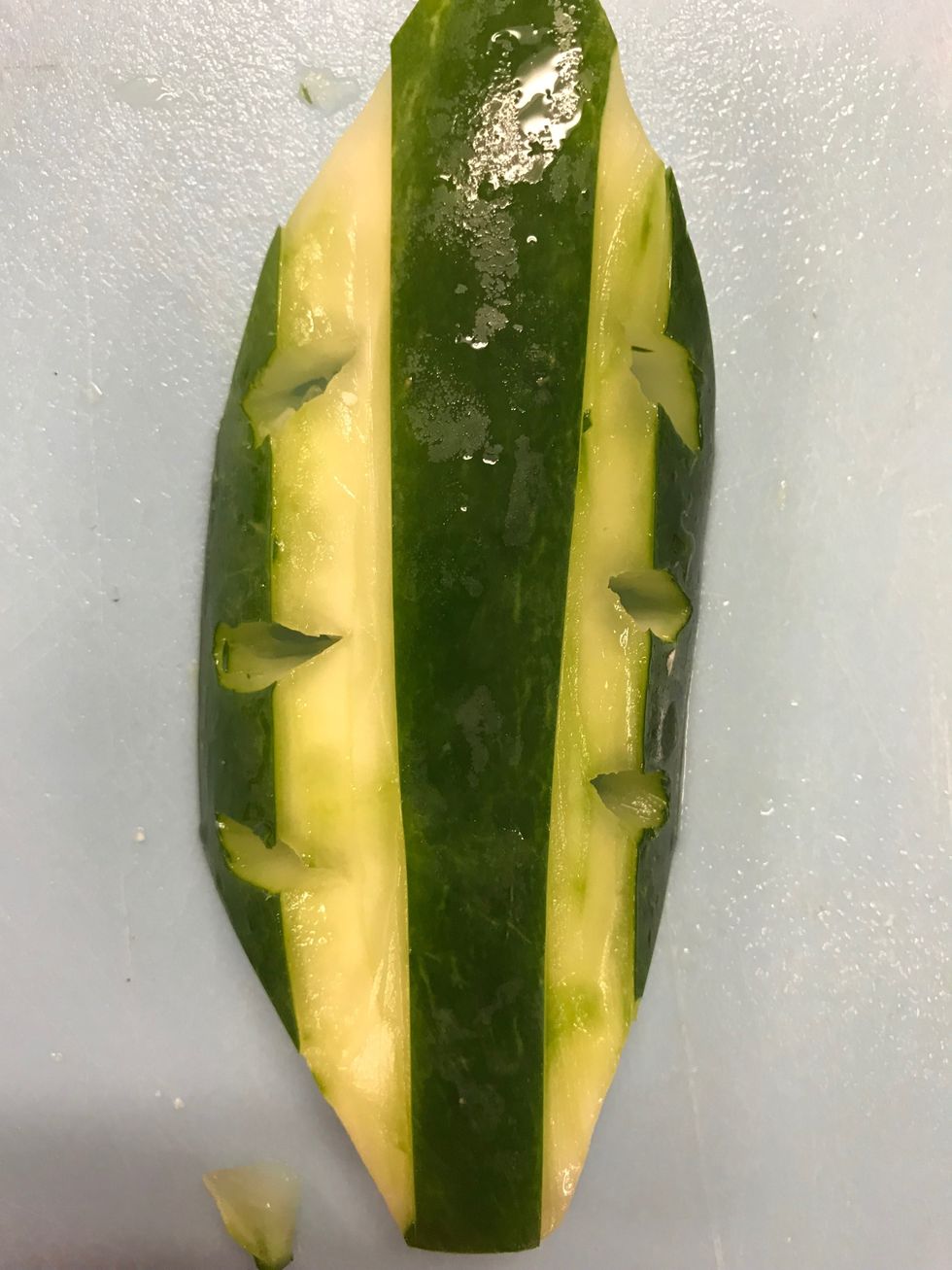 Now cut three small oval holes on each side of the cucumber equally spread out the holes.