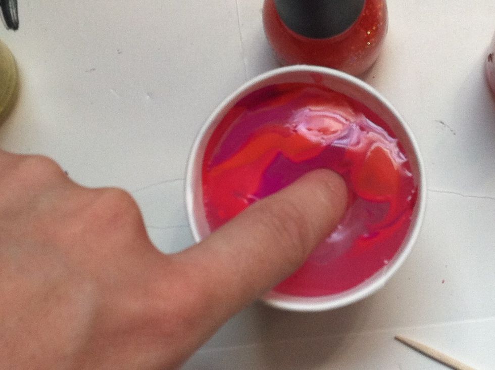 Now dip your nail into the water, lifting up a layer of polish. Don't worry about polish on your finger, the petroleum jelly will make it come off easily.