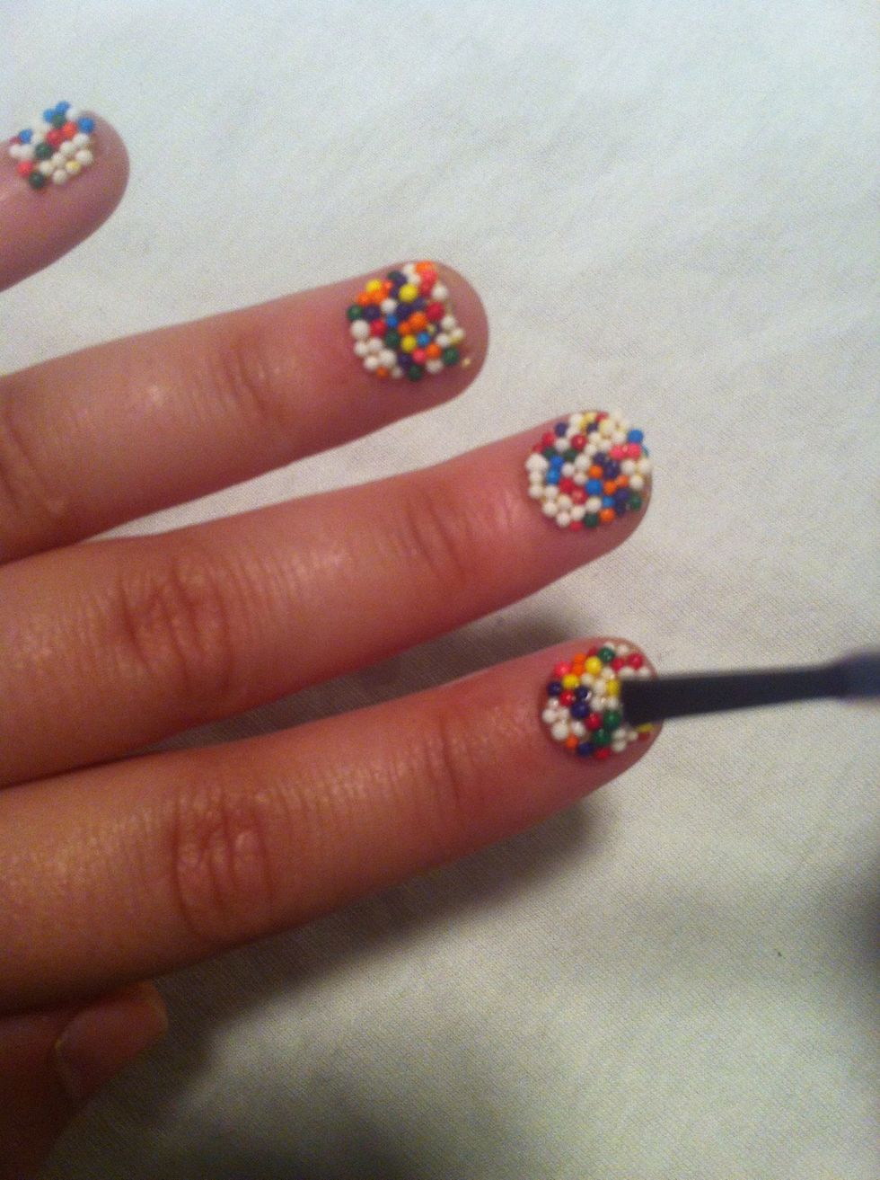 Now-- DO NOT BRUSH ON THE TOP COAT-- whew.. Sorry about that. Brushing it on will smear the sprinkle color. Instead, dot on thick drops and spread them if need be. This keeps the sprinkles intact.