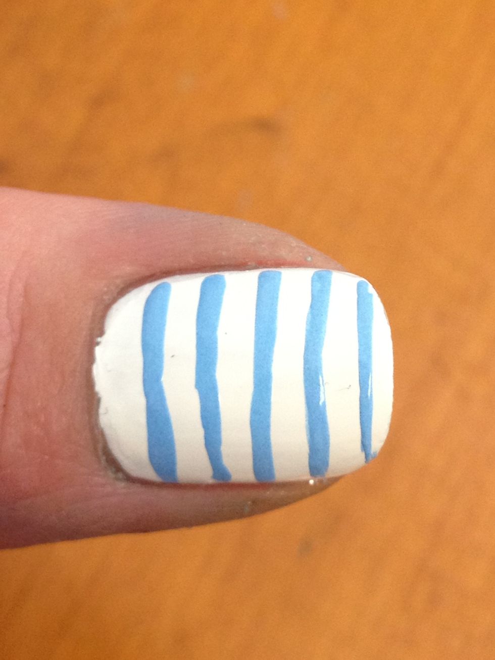 Now do some parallel blue stripes. You can use a paint brush if your nail polish brush is too thick. Just clean it in nail polish remover as soon as you are done:)