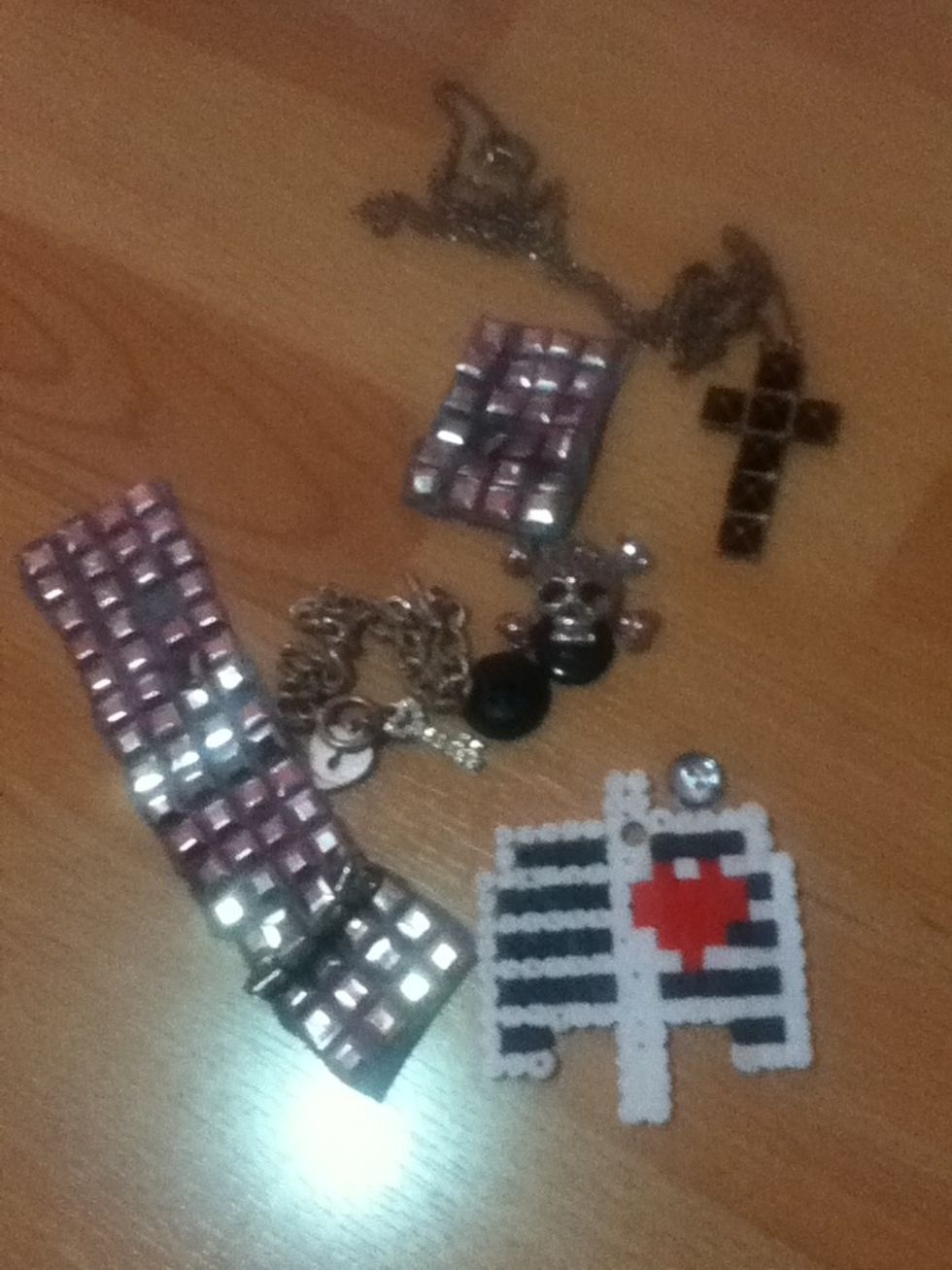 Now do the same with your bad girl things! I used studs from an old shirt, crosses, chains, and a perler bead heart in a rib cage that I made.