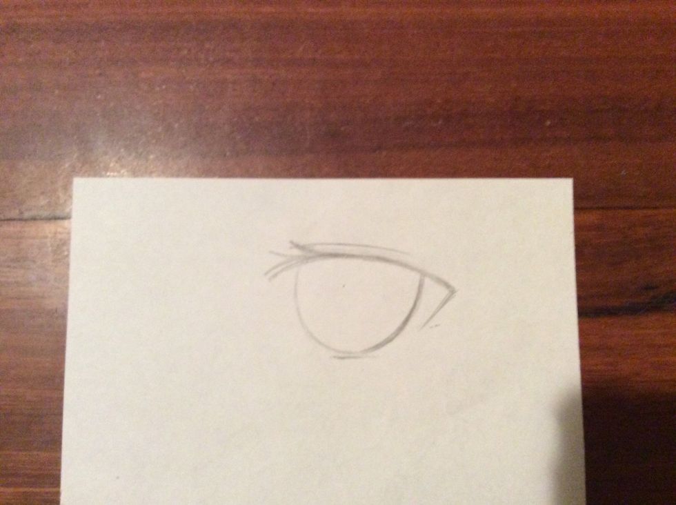 Now draw a nearly full circle that's slightly too big for the eye. Make sure to leave some space for the whites. Do not go over the lid. The rim of the circle has to just touch the short line.