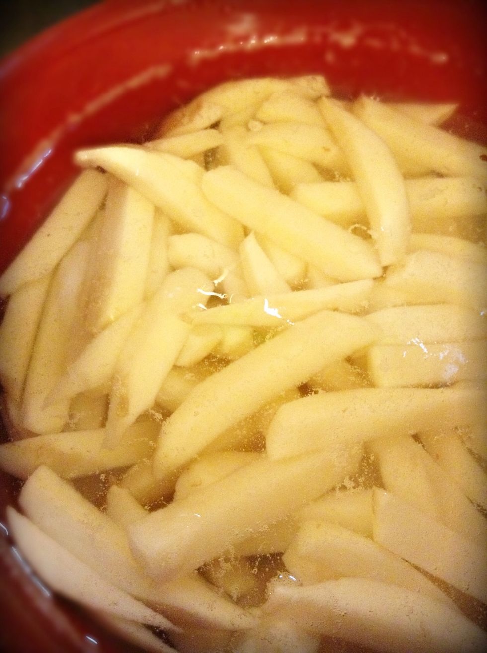 Now fill the bowl of fries with cold water and then get yourself a pot, fill it with water place just a dash of salt in it then place it on medium heat and wait for it to boil.