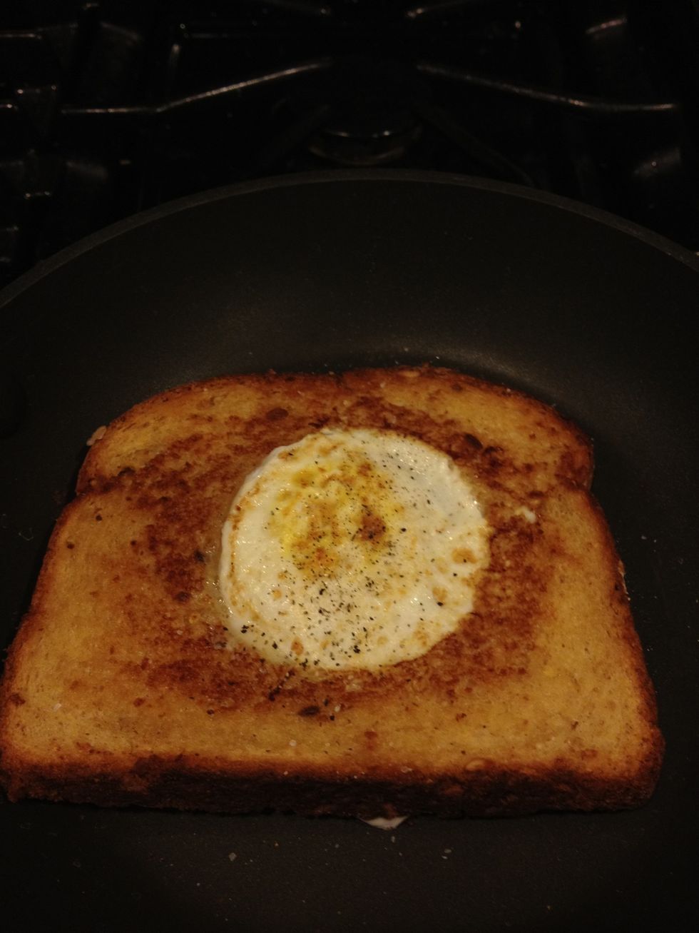 Now flip it. You can see the egg has been cooked nicely on side one. The egg has cooked into the edges of the bread nicely. Again salt-and-pepper. Cook the second side about a minute or so.