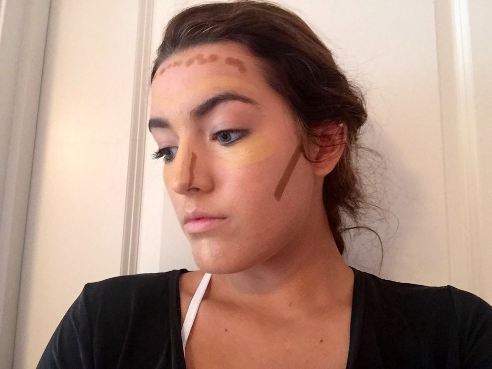 Now flip to the other side of your contour stick which is the lowlight and apply on both sides of your nose, upper forehead and under cheek bones.