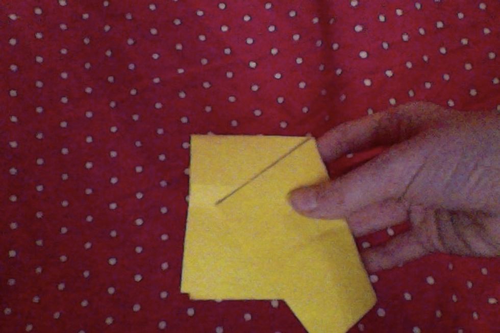 Now fold one side so that the corner meets the line across the center.