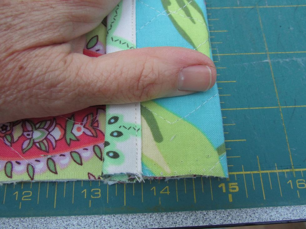 Now fold this trimmed edge down towards the needle pocket at the other end and secure it with pins, clips, or basting stitches. This forms a tiny pocket to keep needles from falling out!