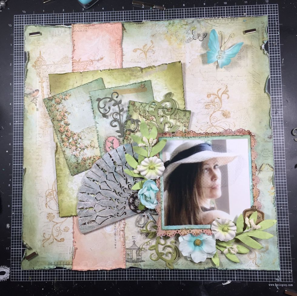 Now for flowers and other embellishments. I tore the bottom layer of the butterfly to make it smaller. I added a wood purse at the end of the flower cluster, and a brad to the fan.