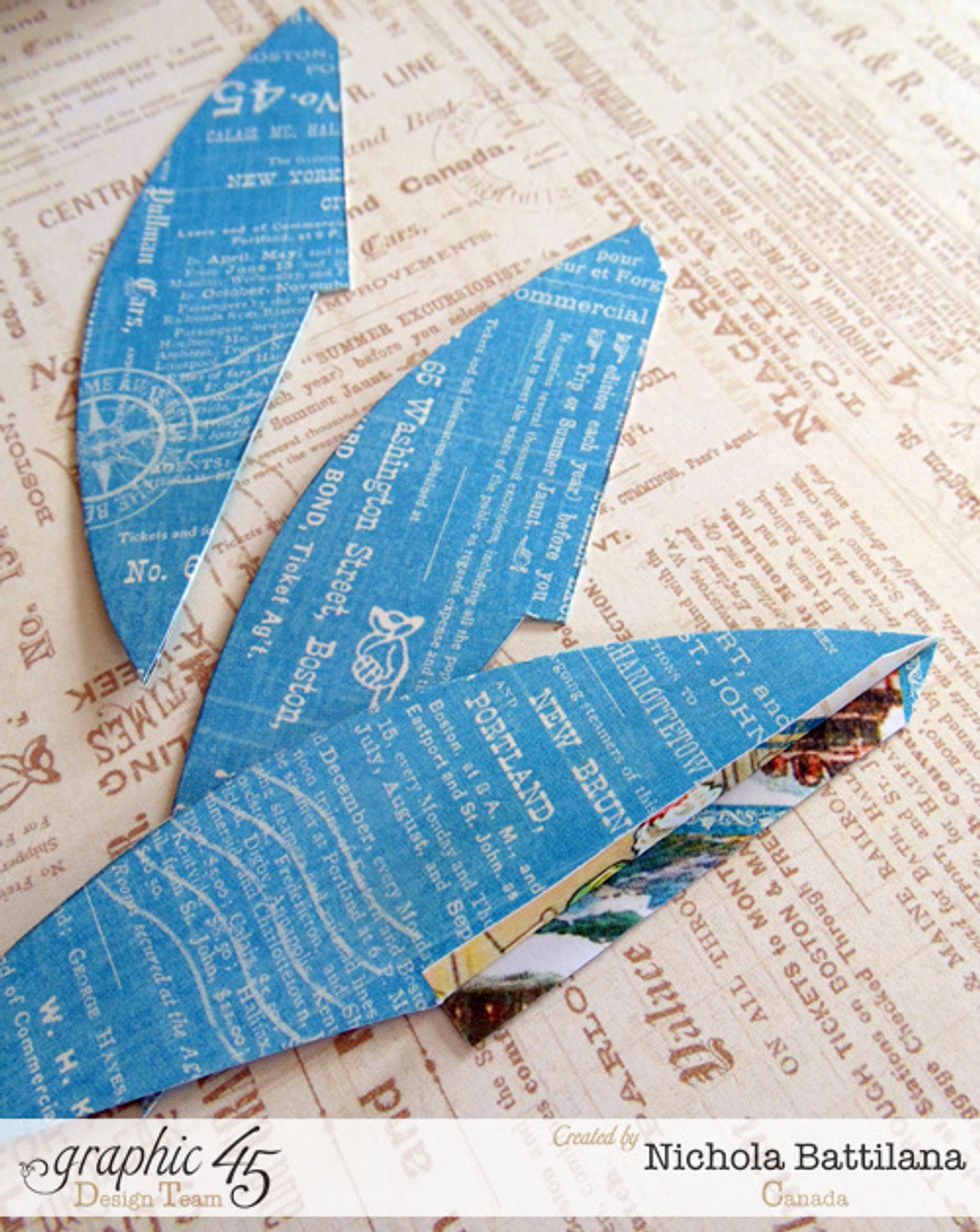 Now for the fins! Cut the fin shapes from Graphic 45 > Come Away With Me > Wanderlust and adhere the two matching halves. Ensure that the fold is free so that you can fold it like this.