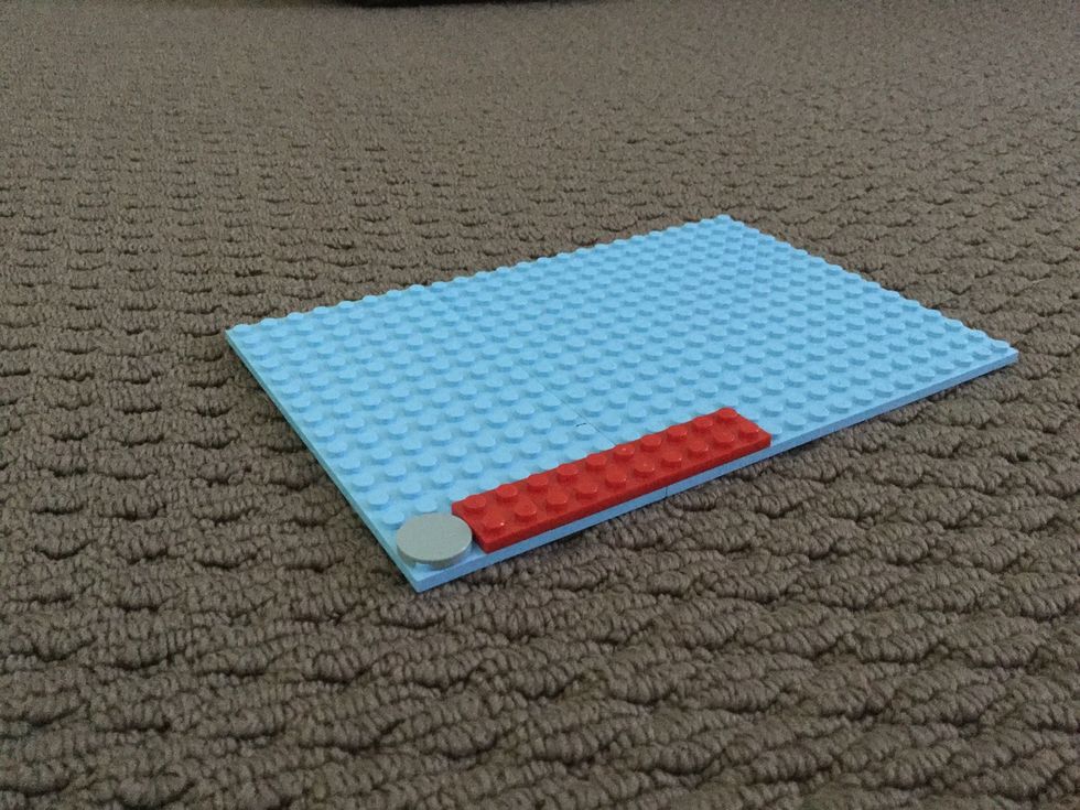 Now get a blue square and connect the two blue rectangular to it using the two long red pieces.