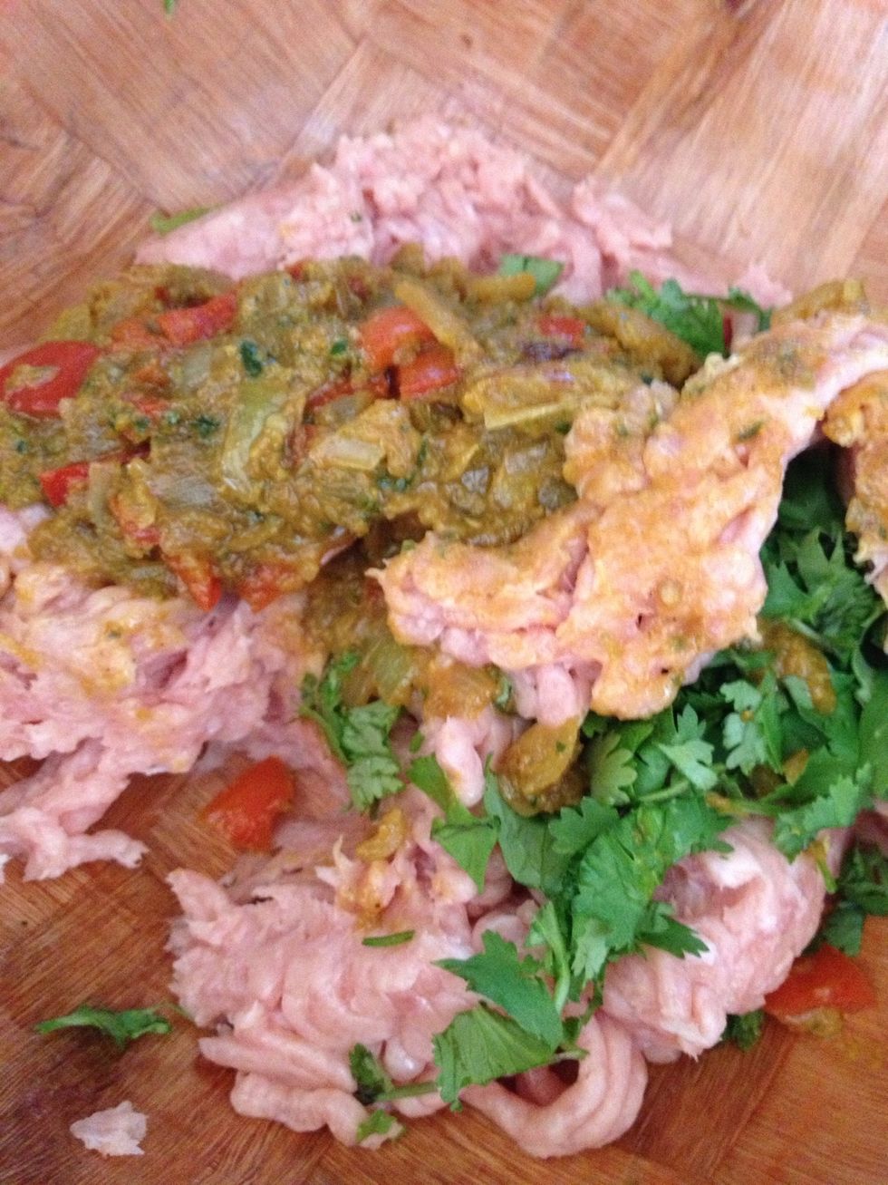 Now get minced chicken in a bowl I used one pack which will make 4 burgers. Get onions and peppers mixture and mix all ingredients well with the chicken. I added cilantro too for a more Indian flavor