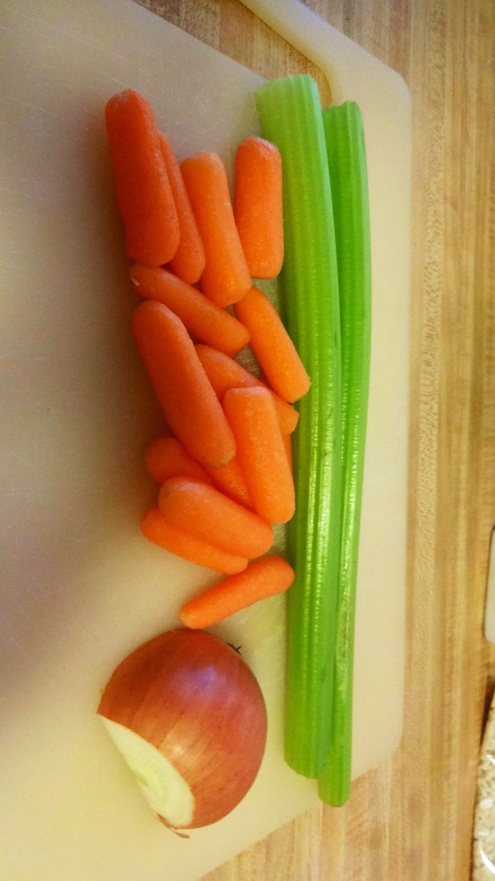Now get the celery stalks, carrots, and the half onion. Chop them up into small pieces.